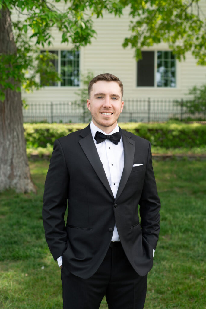 groom wearing a black tux and black bow tie on his wedding day