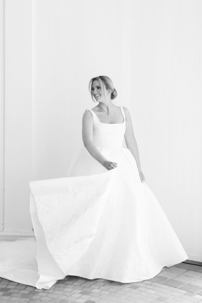 bride twirling her dress back and forth as she smiles over her shoulder