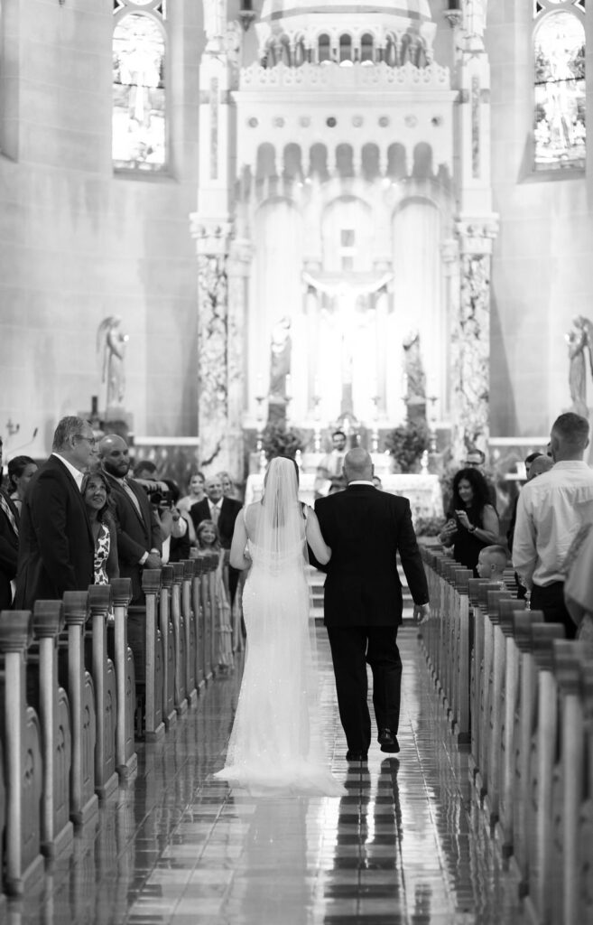bride walking down the aisle with her dad at Basilica of St. Adalbert in downtown Grand Rapids