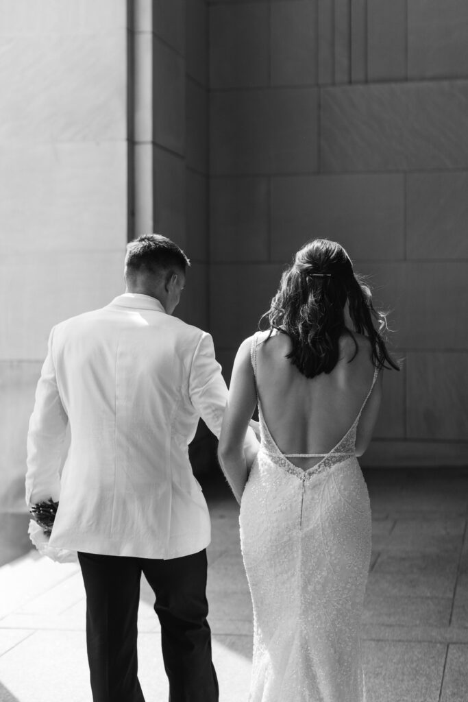 bride and groom holding hands and walking at the Civic Auditorium in downtown Grand Rapids, Michigan