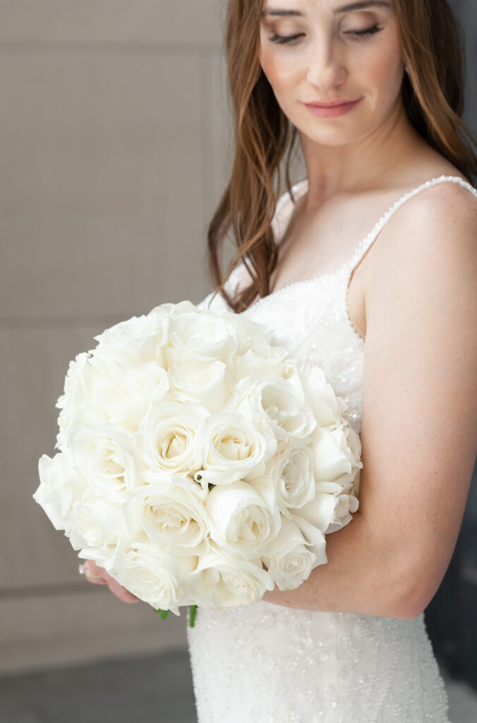 bride holding a bouquet of white roses