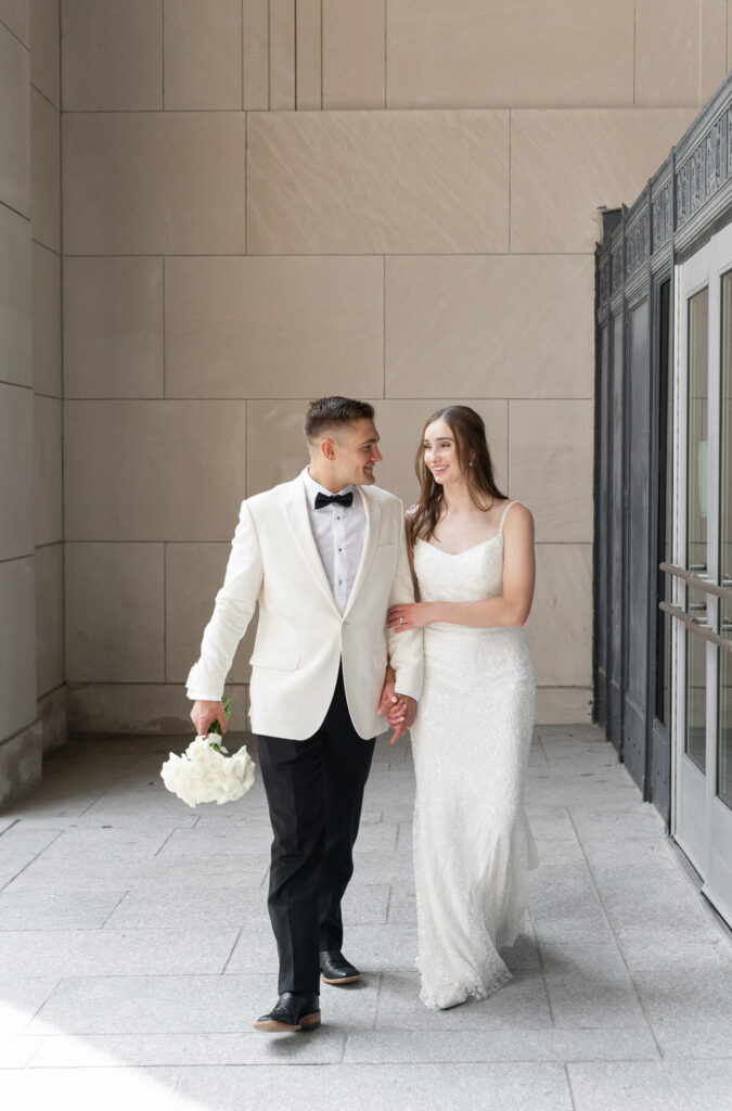 bride and groom walking in the exterior hallway of the Civic Auditorium in downtown Grand Rapids