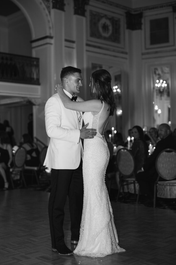 bride and groom embrace during their first dance inside a ballroom in downtown Grand Rapids