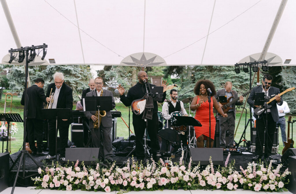 Bluewater Kings Band performing on stage under a sailcloth tent for a Holland Michigan wedding