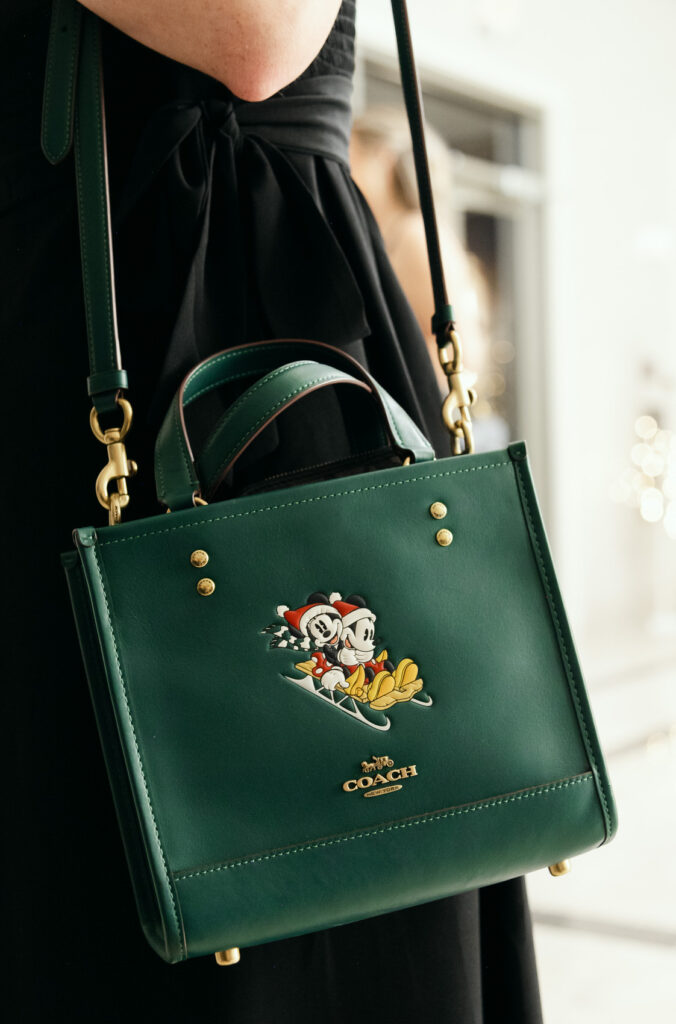 green Coach purse with Micket and Minnie Mouse sledding