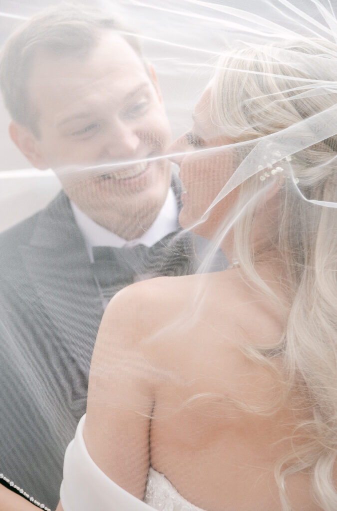 bride and groom snuggle under the veil during their winter wedding in Detroit