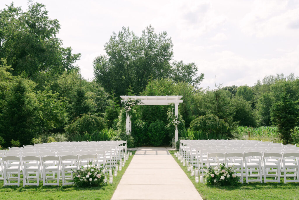 Wedding ceremony location at the Bay Pointe Inn Woods on a sunny summer day