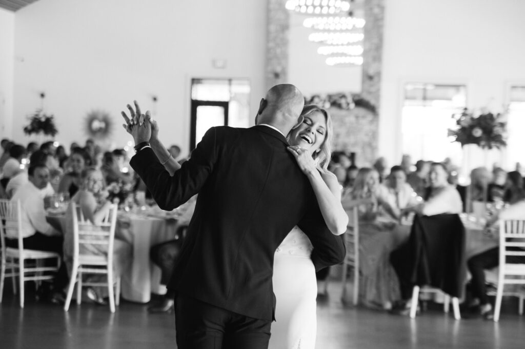 Bride and groom dancing inside the ballroom at their summer wedding at Bay Pointe Woods in Shelbyville, Michigan