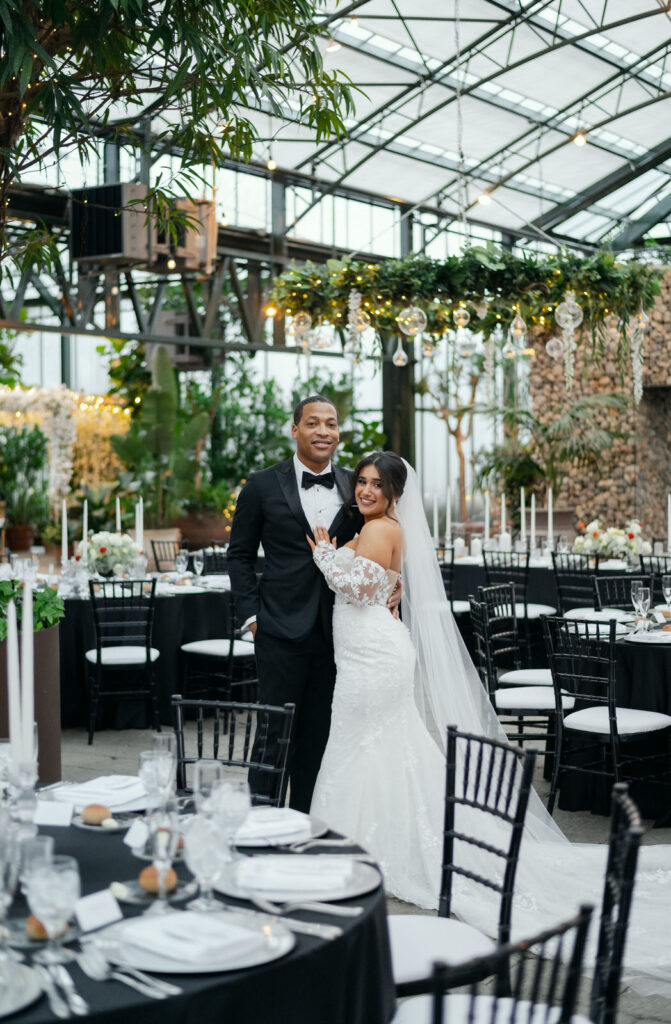bride and groom smiling in the middle of their extravagant wedding reception room at Planterra Conservatory in West Bloomfield, MI