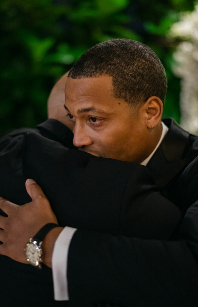 groom sheds a tear while hugging his brother during his wedding ceremony