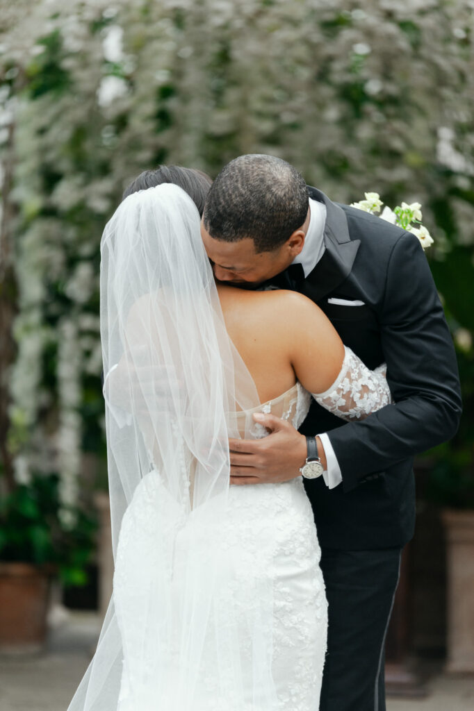 groom embraces his bride after their emotional first look at Planterra