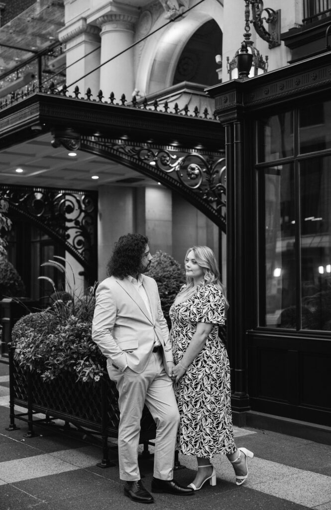 couple holding hands and looking at each other in front of the Amway Grand Plaza Hotel