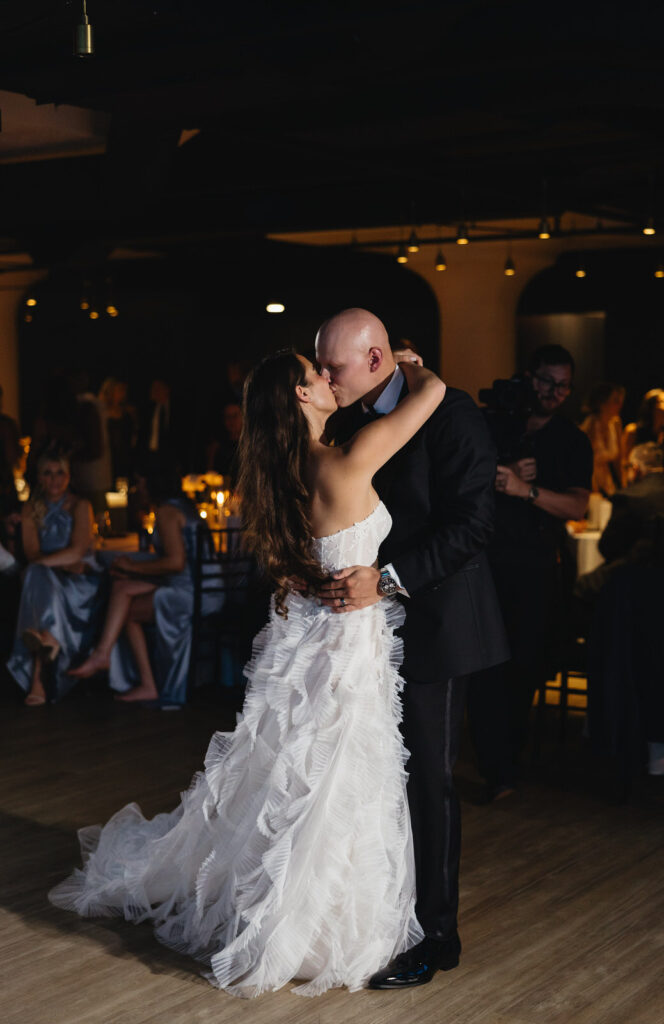 bride and groom kiss on the 9th floor of Chroma Detroit during their first dance