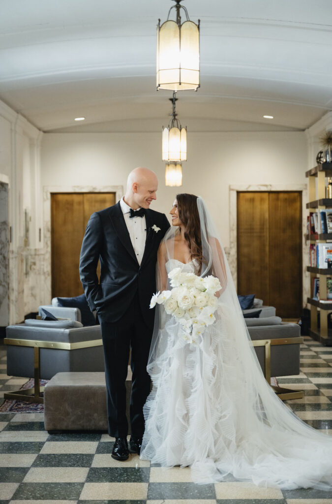 bride and groom smile at each other