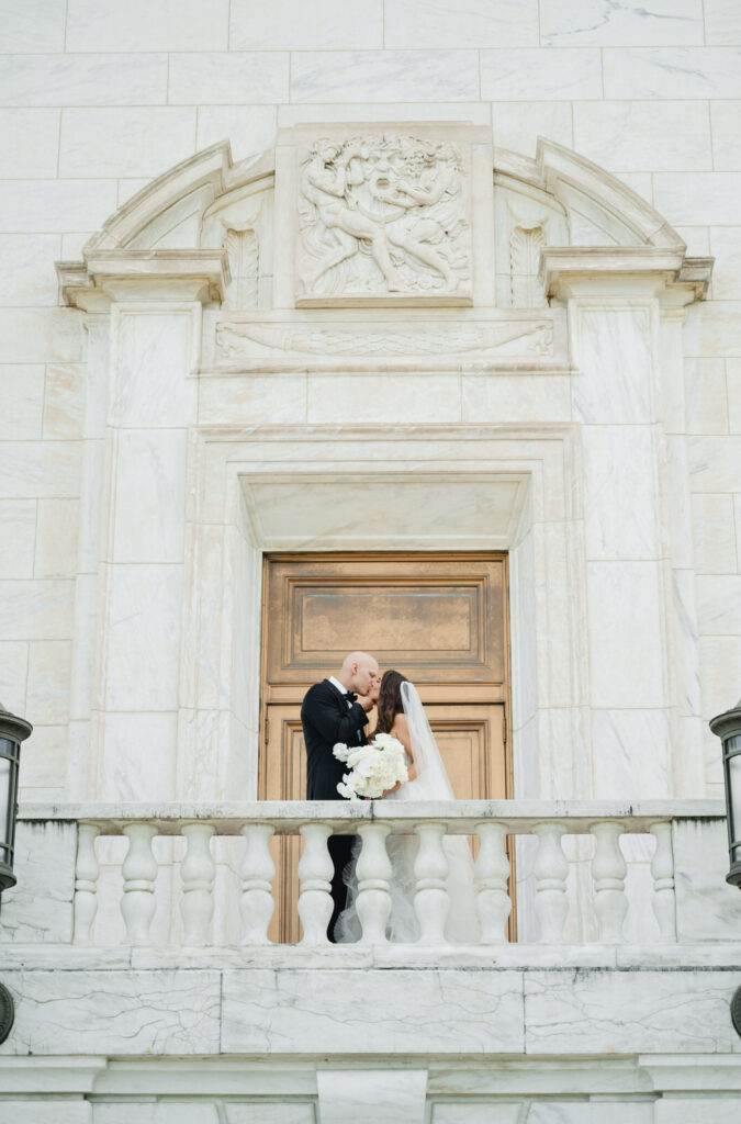 bride and groom kissing on the balcony of the Detroit Institute of Arts