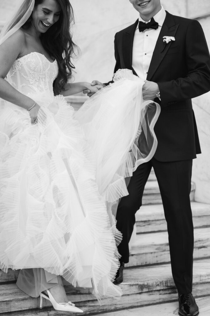 groom guiding his bride down the marble staircase of the Detroit Institute of Arts