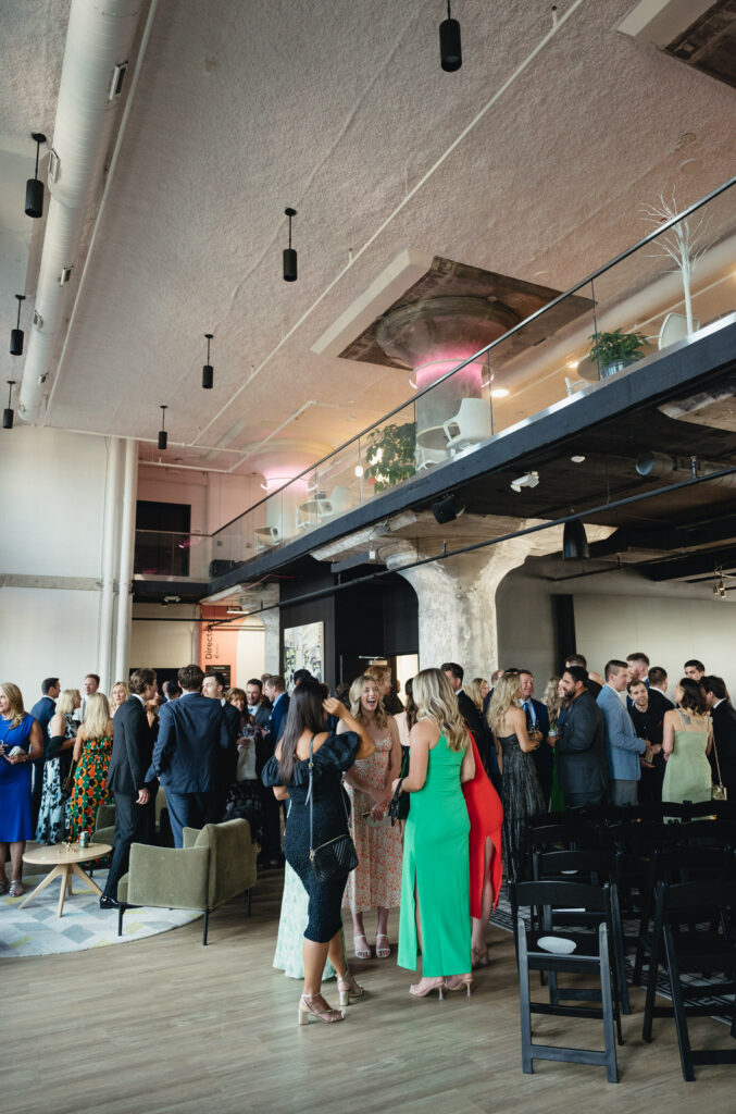 wedding guests talking and mingling on the main level of Chroma Detroit during cocktail hour