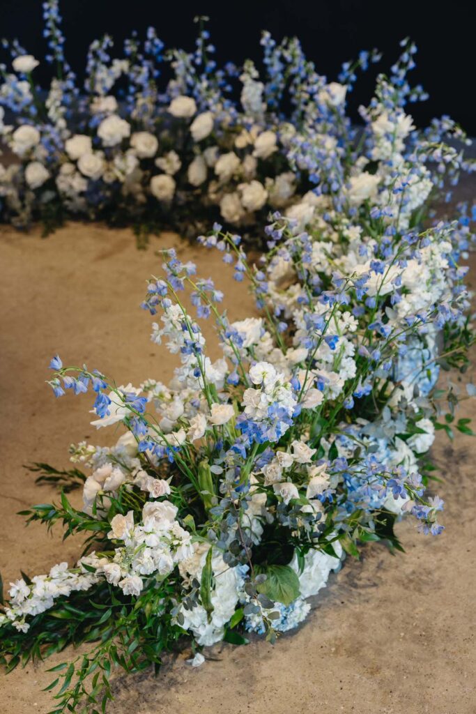 blue and white floral arrangements by Emerald City Designs sitting on the main floor of Chroma Detroit for a wedding ceremony