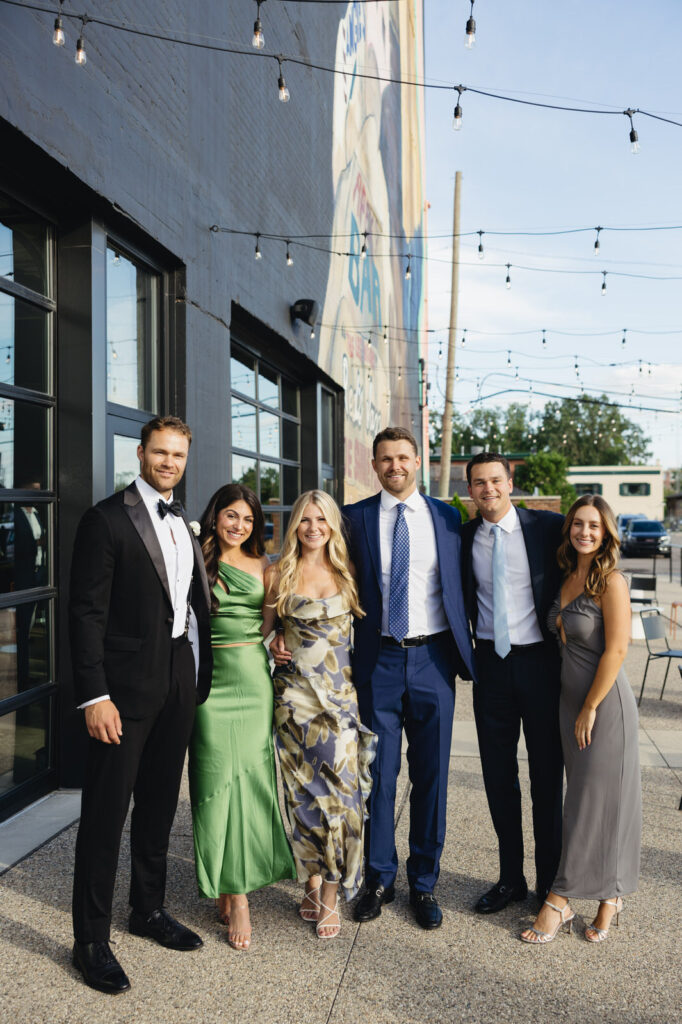 wedding guests posing and smiling outside of Chroma Detroit 