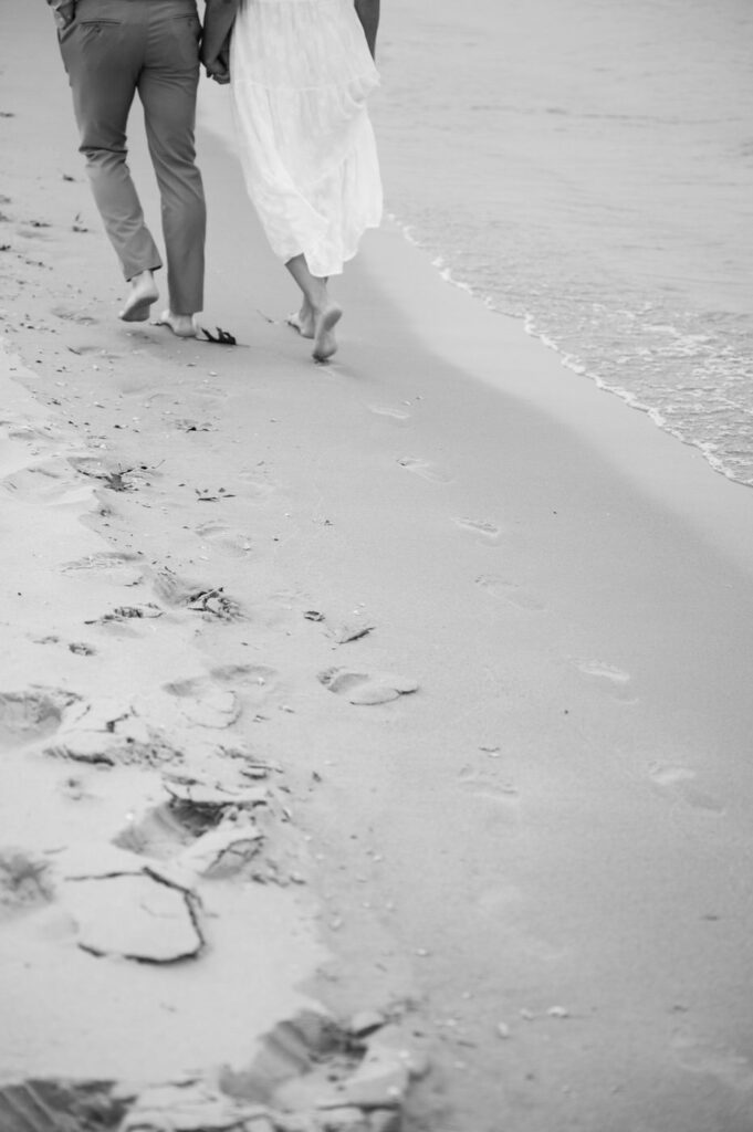 couple's walking footprints in the sand during their South Haven engagement session