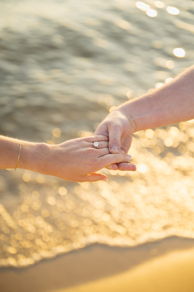 man holding his fiance's hand showcasing her ring at their Engagement session in West Michigan