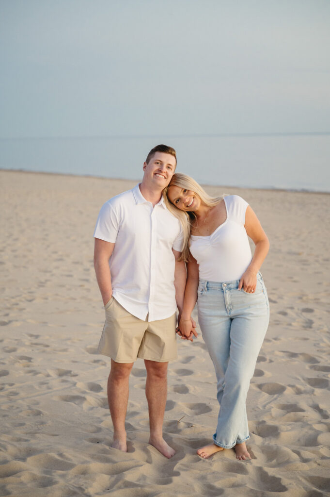engaged couple holding hands at sunset during their West Michigan engagement session