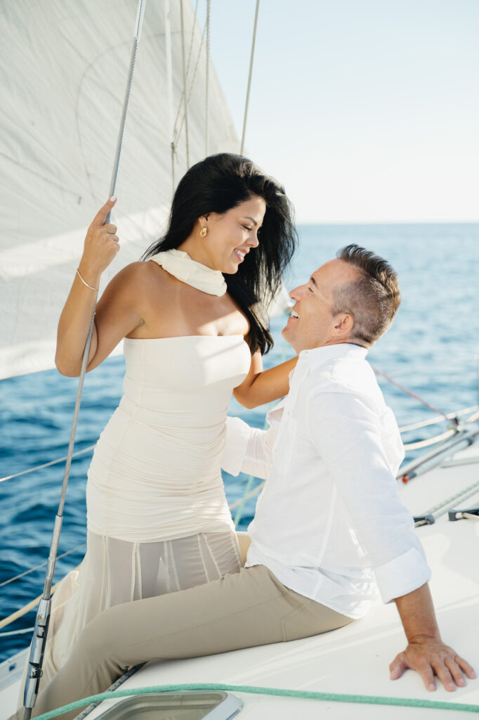 man and woman smiling as they enjoy sailing on a sailboat on Lake Michigan