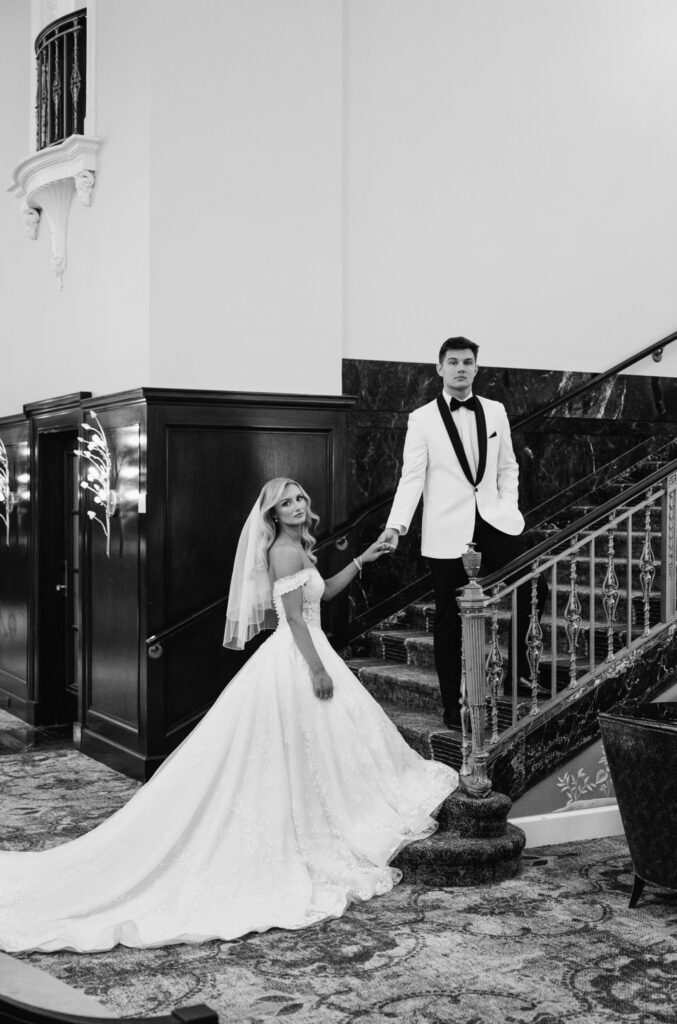 bride and groom on the stairs in the lobby of the Amway Grand Plaza Hotel in Grand Rapids, Michigan